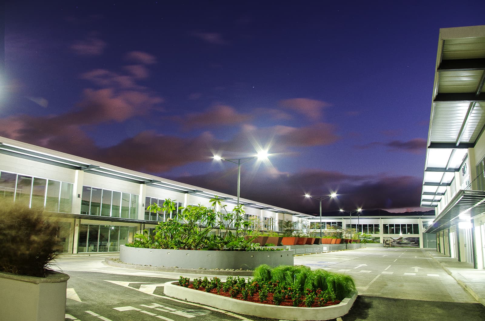 Fachada de Plaza Aeropuerto iluminada de noche
